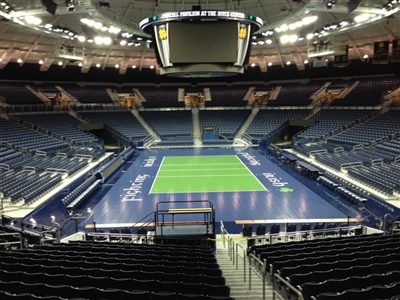 Large indoor arena with a green volleyball court on a blue surface in Cedar Lake.