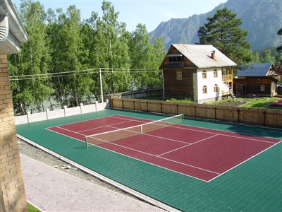 Outdoor sports court with a green and red surface, featuring a tennis net in Maple Bluff.