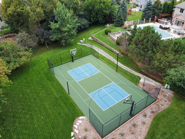 Aerial view of a renovated pickleball and multi-sport court with two basketball hoops in Menomonee Falls, WI