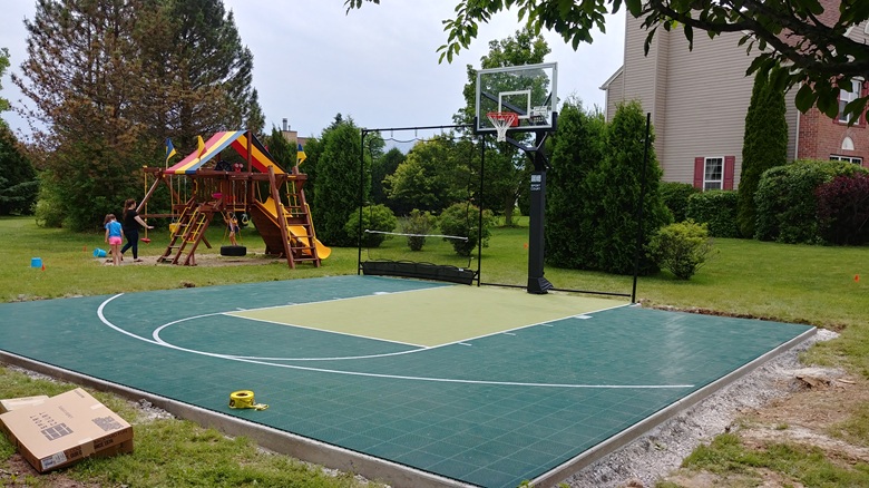 Completed 30x30 backyard basketball court with adjustable hoop and rebounder net in Menomonee Falls, WI