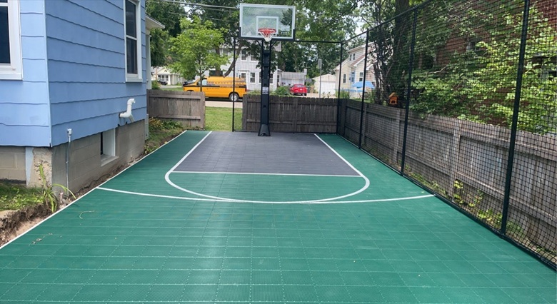 Compact 16x36 backyard basketball court with perimeter containment netting in Madison, WI